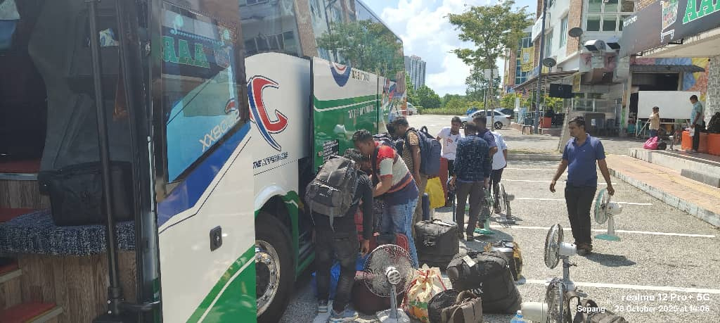 Workers and luggage boarding a bus