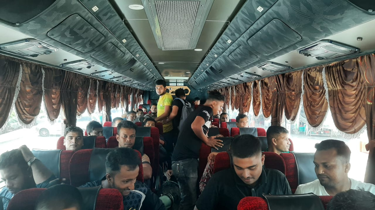 Workers seated inside a bus